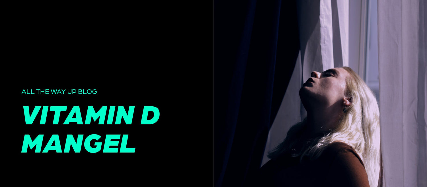 Frau steht erschöpft vor dem Fenster mit geschlossenen Augen – Symbolbild für Vitamin-D-Mangel und Lichtmangel im Winter